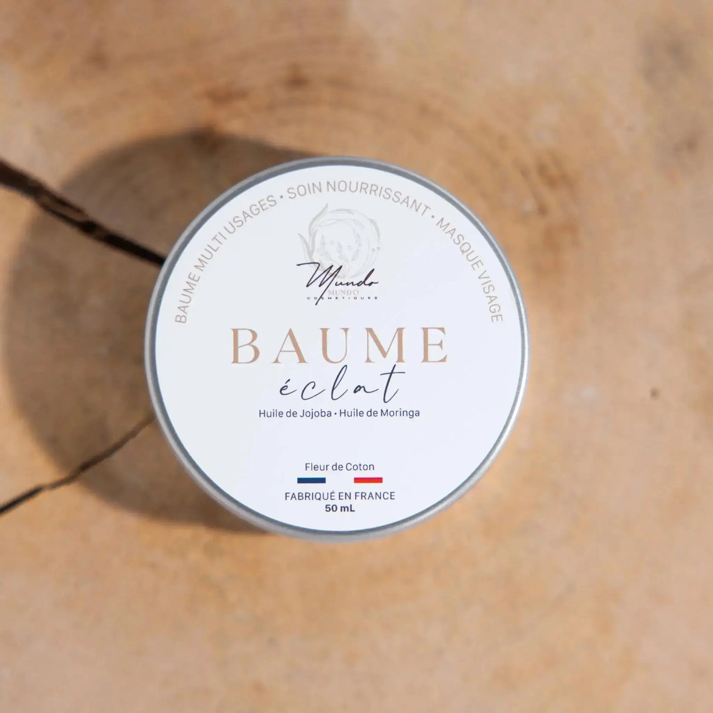 Image du baume éclat fermé posé sur un rondin de bois