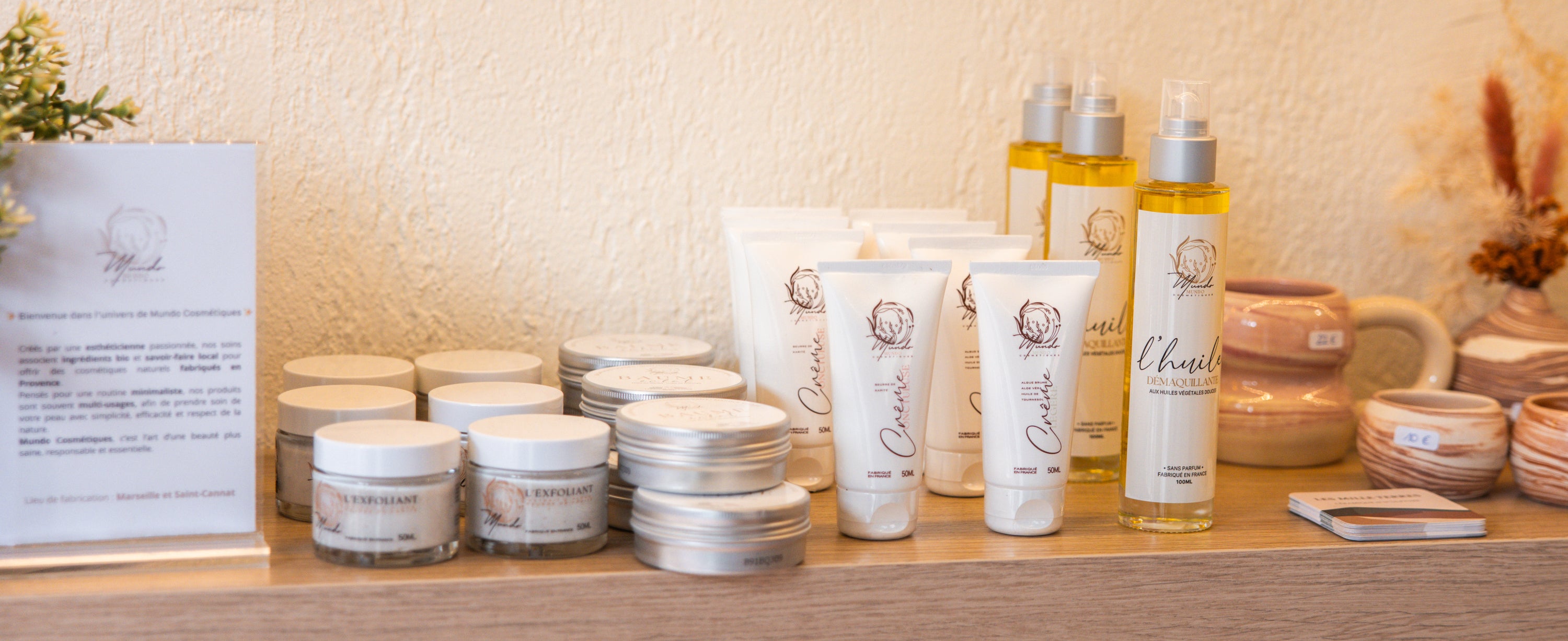 photo de l'étagère de la boutique Mundo Cosmétiques à Cabriès, elle présente les produits l'huile démaquillante, le baume multi usage et la crème légère / onctueuse