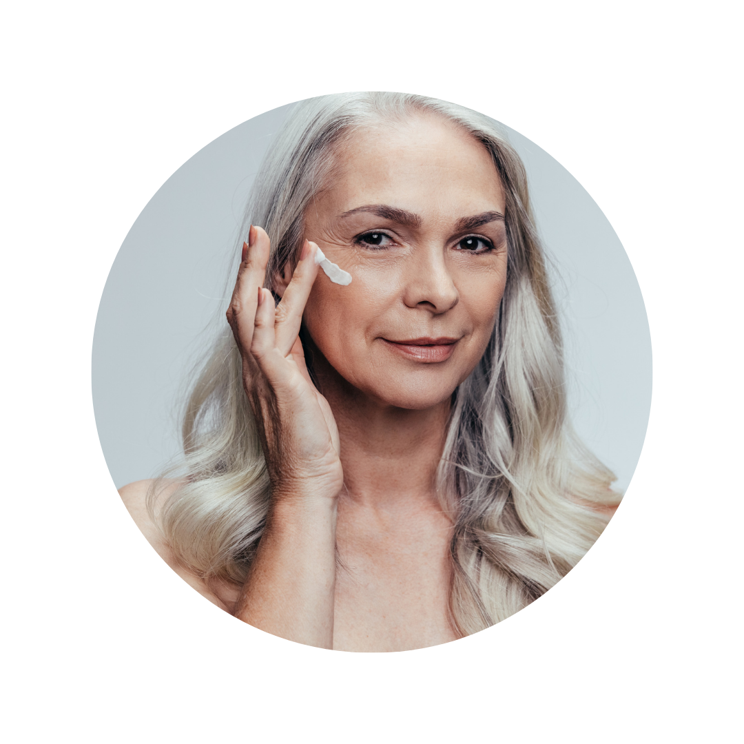 Image d'une femme à la peau mature et légèrement ridée qui s'applique de la crème sur le visage