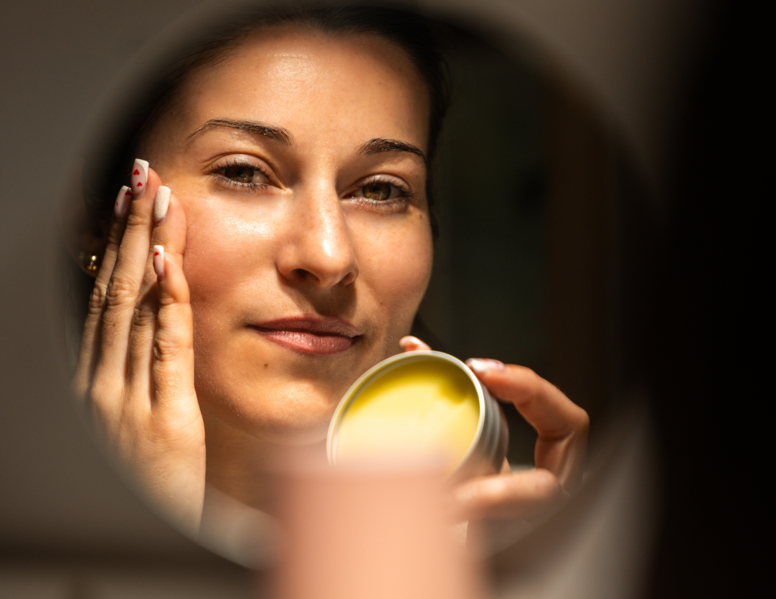 Image d'une femme appliquant le baume hydratant visage