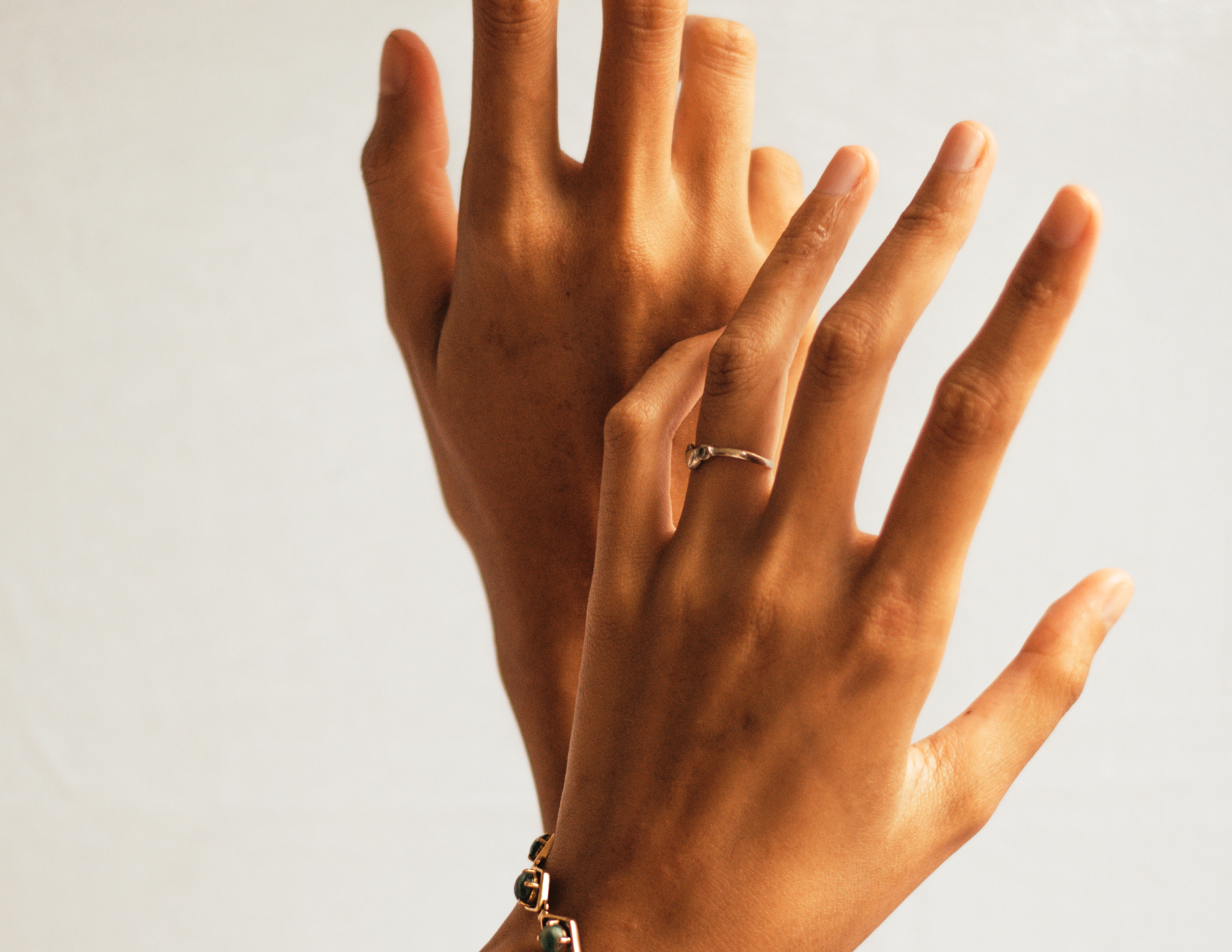 Image de deux mains avec bagues et bracelets