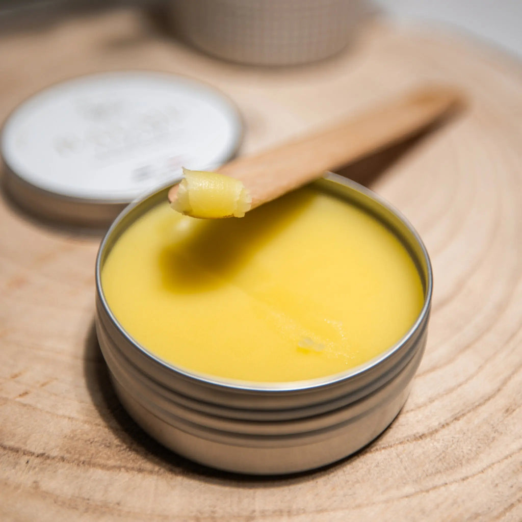 Image du baume éclat Mundo laissant apparaitre la texture avec un copeau du baume déposé sur une spatule