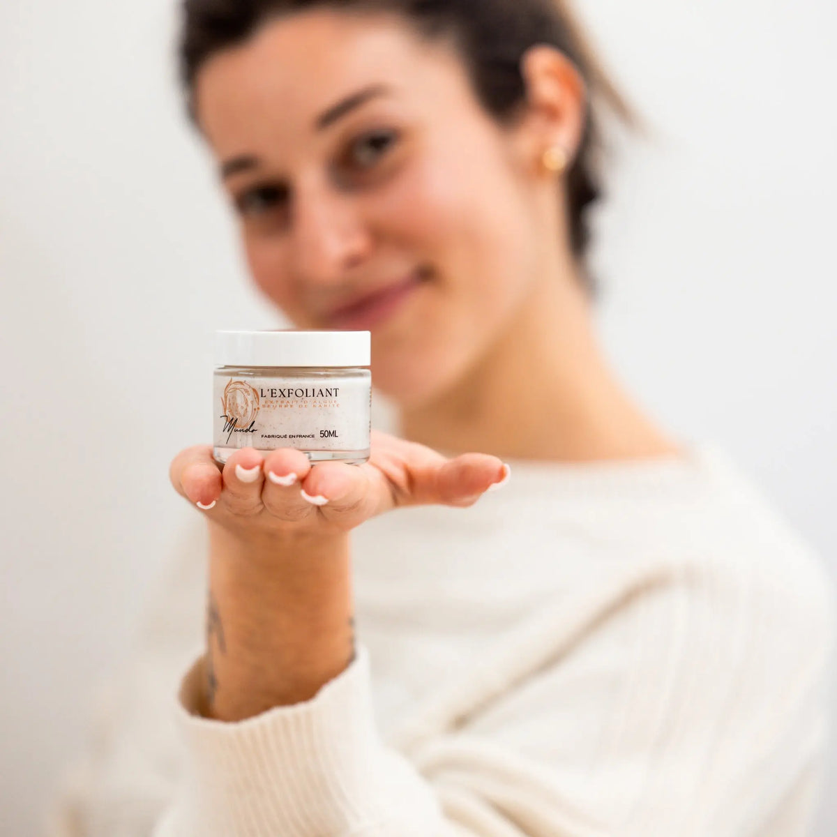 Image du gommage tenu dans la main d'une cliente